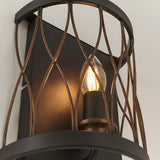 Close-up of Endon Hulton wall light showing lit E14 candle bulb within a matt black and rustic bronze steel cage with curved lattice detail.