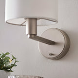 Bexley Wall Light in nickel with a white fabric shade, shown mounted on a wall with a switch on the round base and angled arm.