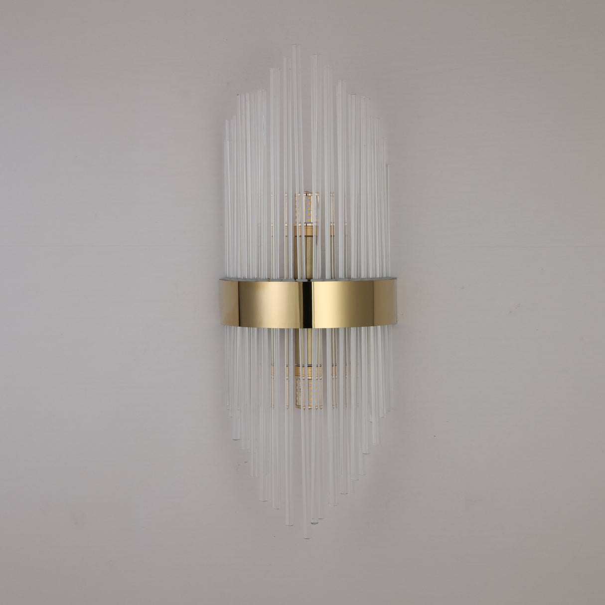 The Oriana 2 Light Crystal Wall Light - Gold showcases vertical glass rods and a central gold band, offering elegant luxury lighting that enhances any light-colored wall.