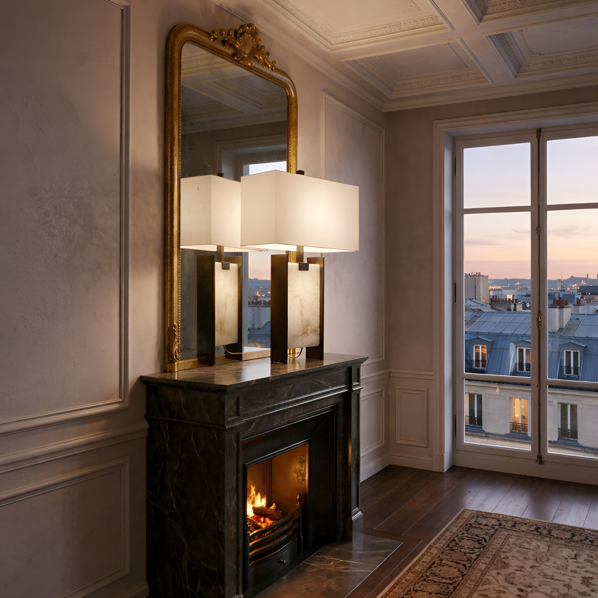 Elegant room with a marble fireplace, lit fire, and the Valcera 1 Light Framed Vertical Alabaster Table Lamp in Black & Soft White beside a large mirror. Tall windows showcase a sunset cityscape, while warm lighting adds cozy charm.