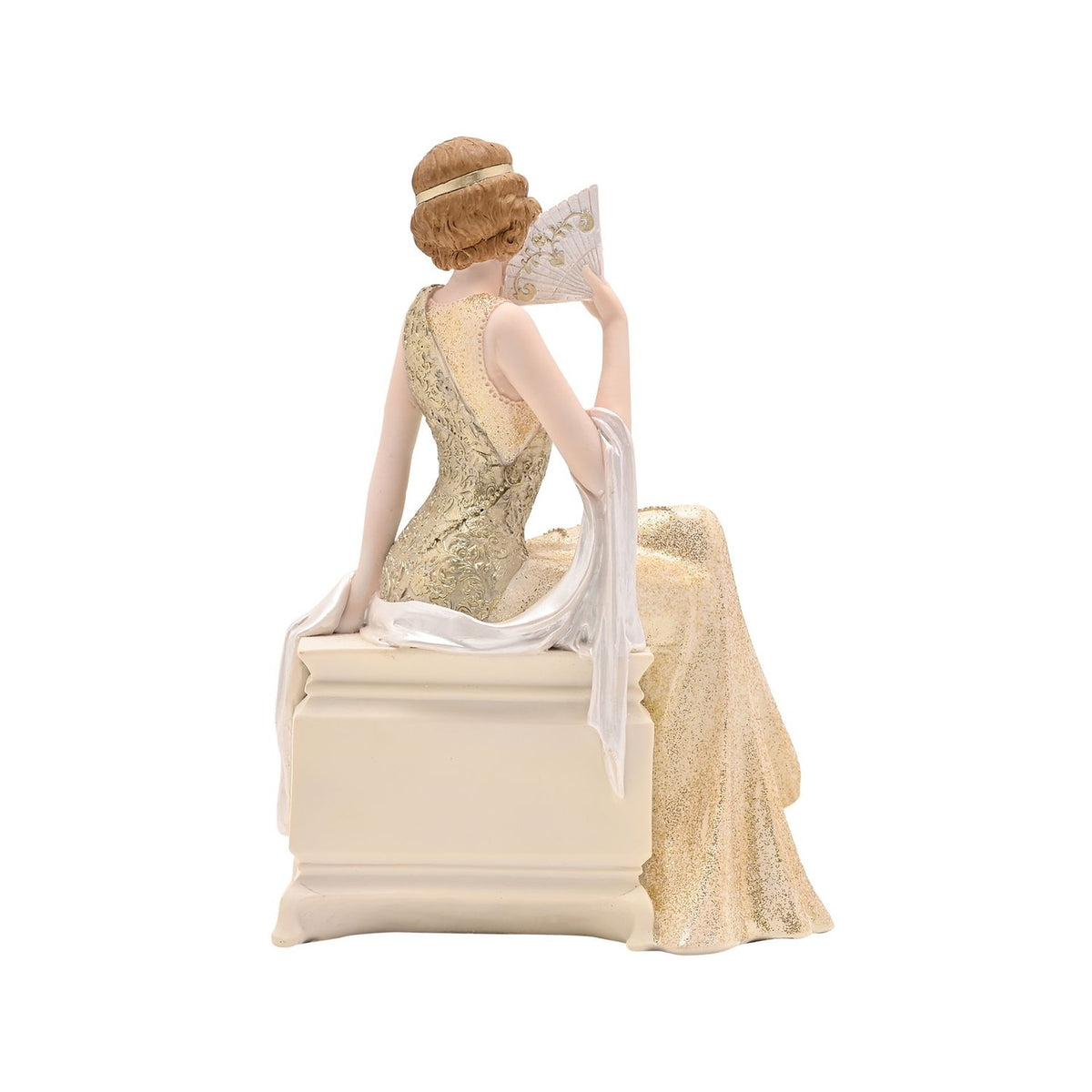 Golden Gatsby Lady resin trinket box, rear view showing a 1920s lady in a pale gold scrollwork gown seated on a cream chest with drawer, holding a fan, on a plain white background.