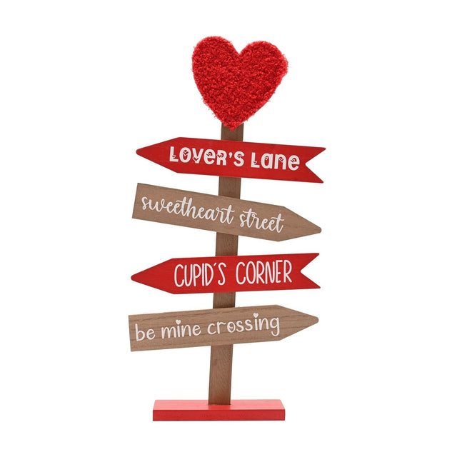Valentine's MDF signpost with a textured red heart topper and four arrows reading Lover's Lane, Sweetheart Street, Cupid's Corner, and Be Mine Crossing, on a slim post with red base.