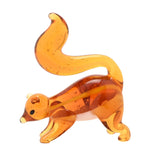 Miniature glass squirrel figurine in translucent orange with a tall curled tail, white underside, yellow back streak and visible bubbles, shown on a plain white background.