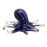 Swirl Octopus Glass Figurine with a deep blue head streaked in brown and white, round black eyes, and clear glass tentacles spreading outward on a plain white background.