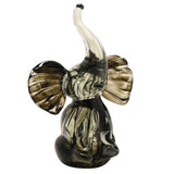 Trumpet Elephant Streaked Glass Figurine in black and grey, seated with trunk raised and wide ribbed ears, dark streaks fading to clear glass, on a plain white background.