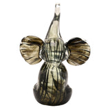 Trumpet Elephant Streaked Glass Figurine in black and grey, seated with trunk raised and wide ribbed ears, dark streaks fading to clear glass, on a plain white background.