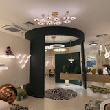 Calyra Large LED Alabaster Semi-Flush Ceiling Light with twelve brass-framed alabaster panels arranged at varying heights, shown installed above a curved green archway.