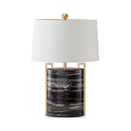 The Obrion 1 Light Framed Marble Table Lamp in brass and black features a cylindrical black marble base with white and brown veining, metal accents, and a large white drum shade—perfect for adding architectural flair to any interior.