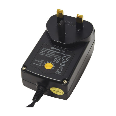 Mercury SMDC406UK 27W switch-mode power supply with UK plug, yellow rotary voltage selector, and printed specification label on black casing.