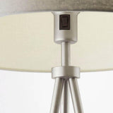 Close-up of the Endon Cranwell Floor Lamp's nickel lampholder with rocker switch beneath a grey linen-effect drum shade, above splayed tripod legs.