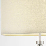 Close-up of the Endon Cranwell floor lamp showing the grey linen-effect drum shade and brushed nickel lampholder stem.