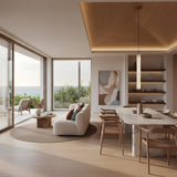 A modern, minimalist living and dining area with light wood floors, neutral furnishings, ocean views, marble dining table, wooden chairs, abstract wall art, and the Zenvia LED Alabaster Single Pendant Light in brushed brass & soft white overhead.