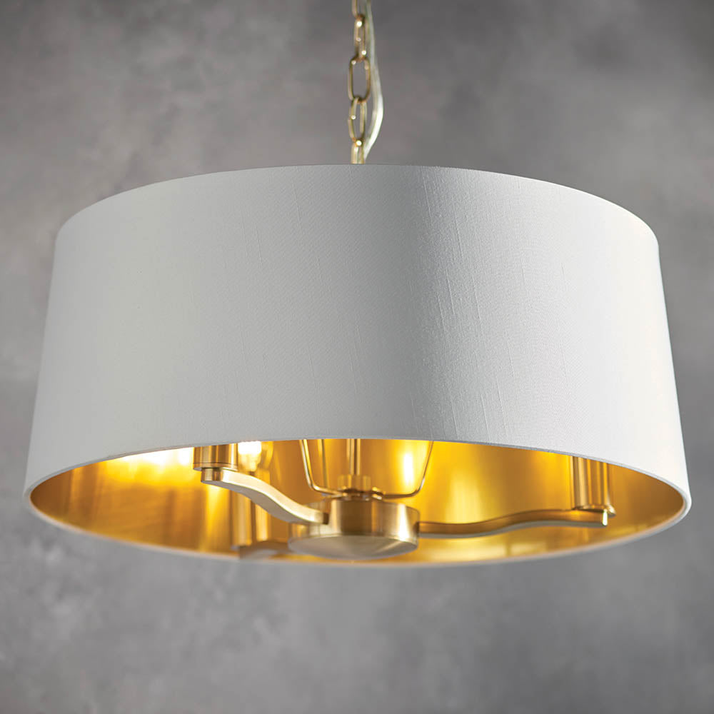 Endon Brendale 3 Light Pendant with vintage white faux silk shade and metallic gold lining, suspended from a chain against a light grey background.