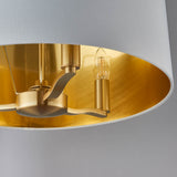 Close-up of Endon Brendale 3 Light Pendant showing brushed gold interior lining, three E14 lamp holders and one lit candle bulb inside the white shade.