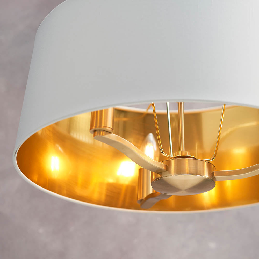Close-up of the Endon Brendale 3 Light Pendant showing three E14 lamps within a white faux silk shade lined with a warm metallic gold interior.