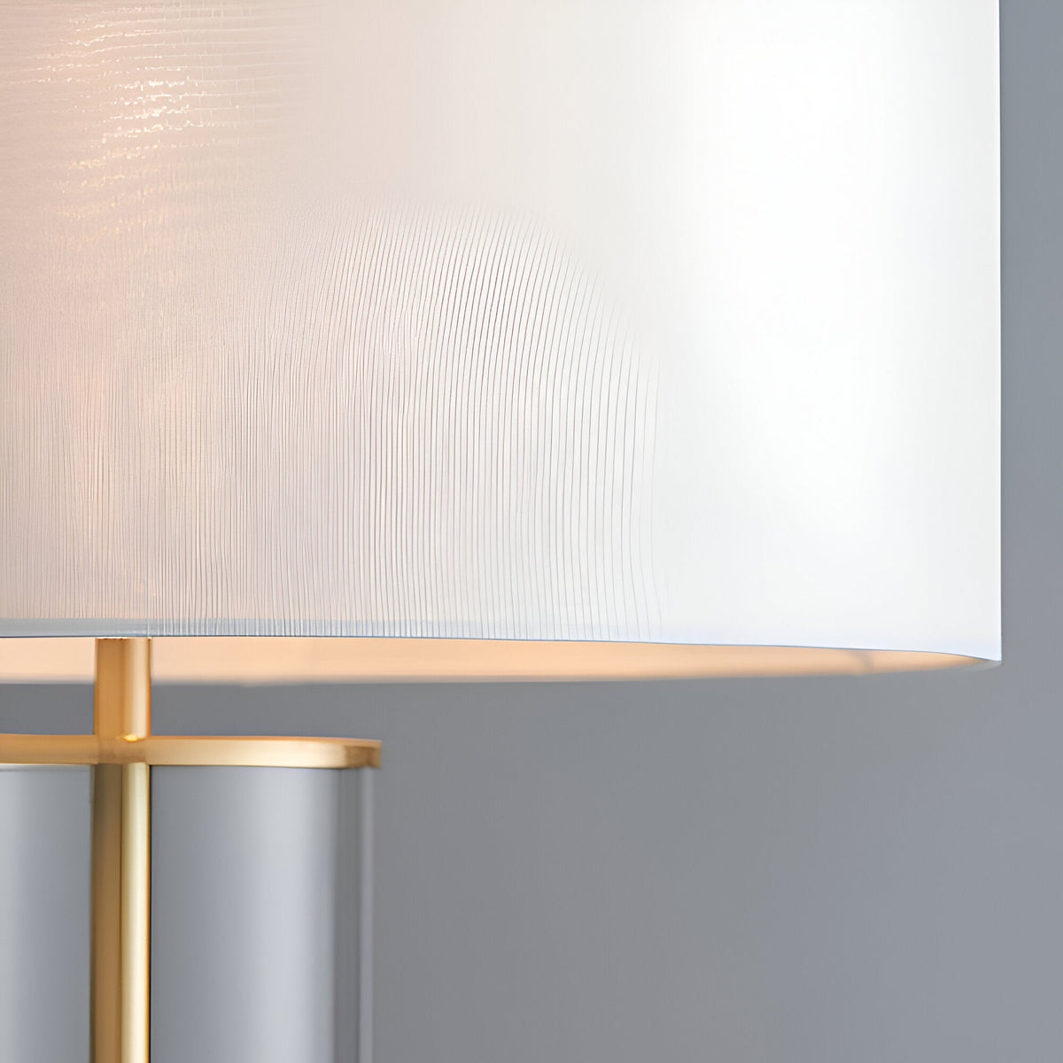 Close-up of the Endon Caldley table lamp showing the vintage white faux silk drum shade and satin brass fitting above the clear glass base.