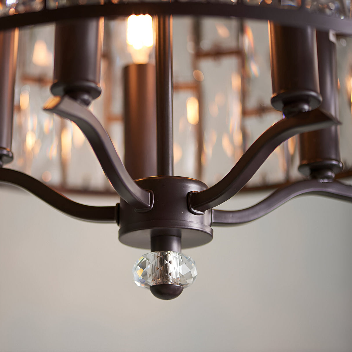 Close-up of the Endon Aldwick 5 Light Pendant in dark bronze, showing curved arms, tiered faceted crystal shade, and a crystal finial detail.