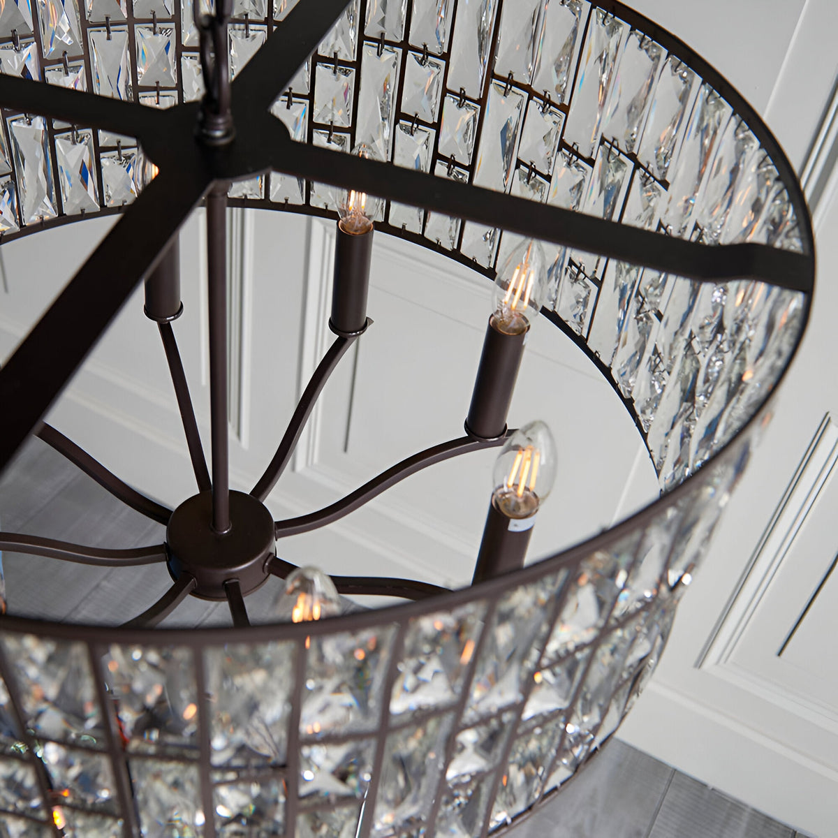 Close-up view of the Endon Aldwick 8 Light Pendant in dark bronze, showing tiered faceted crystal panels, candle-style E14 lamps and metal frame.