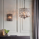 Endon Aldwick wall light in dark bronze with tiered faceted crystals, shown lit beside a matching crystal drum pendant on a panelled wall.