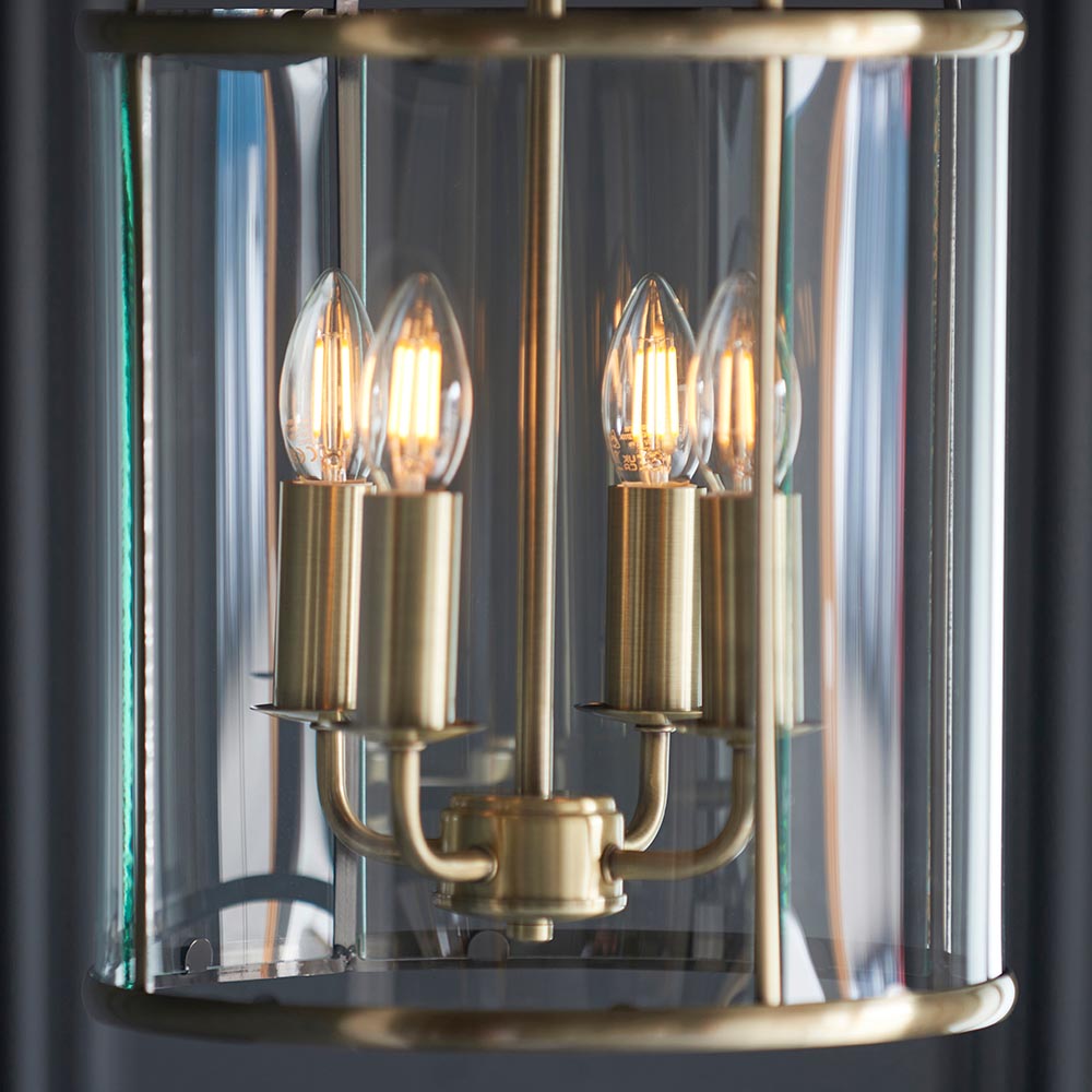 Caldbury 4 Light Pendant in brass, close-up of candle-style E14 bulbs on brass arms within a clear glass panel enclosure.