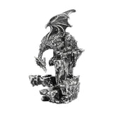 Dragon on Rocks resin figurine with raised ribbed wings and bowed scaled head perched atop a rugged rock column, metallic silver finish with dark shading, on a plain white background.