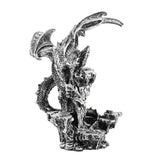 Dragon on Rocks resin figurine in metallic silver, perched with raised ribbed wings and bowed head atop a textured rocky column, tail curling around the base, on a plain white background.