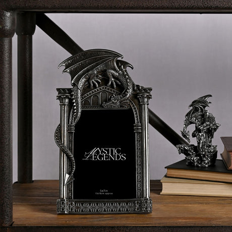 Silver resin photo frame, 7 x 5in, with a winged dragon perched atop a gothic arch, scaled tail down the side, ribbed columns, shown on a shelf beside books and a dragon figurine.