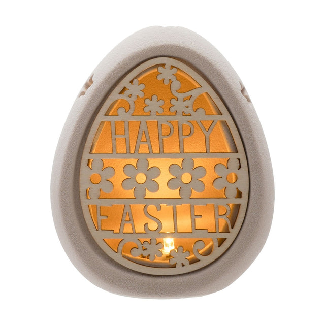 Ceramic egg-shaped light-up decoration in natural finish with a cut-out "HAPPY EASTER" design and floral details, glowing from within, on a plain white background.