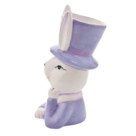 Ceramic planter shaped as a white bunny in a purple top hat and jacket, paw raised to chin, long ears framing the open-topped hat, on a plain white background.