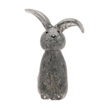 Floppy Eared Sitting Rabbit glass figurine in flecked grey, one ear upright and one curled, black eyes and nose, on a plain white background.