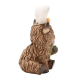 Rear view of the Sitting Highland Cow Easter Bunny resin decoration in brown, showing shaggy fur, horns, and white bunny ears tied with a yellow bow, on a plain white background.