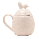 White ceramic mug with lid, featuring a dimpled surface and a lid topped with upright bunny ears, shown on a plain white background.