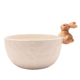 Round white ceramic bowl with a dimpled surface and a sandy brown 3D bunny perched on the rim, shown on a plain white background.
