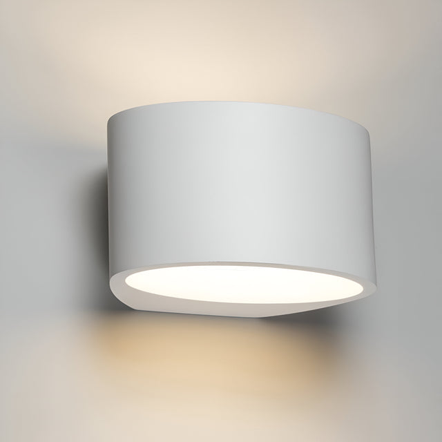 The Curved Up And Down Plaster Wall Light 200mm offers a minimalist and modern design with its cylindrical shape and gypsum plaster construction. This wall lamp provides a soft, warm glow that casts cozy ambient lighting against the wall. With its matte white finish, it delivers a sleek and contemporary look.