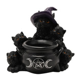 Black resin tealight candle holder shaped as five amber-eyed cats around a cauldron with a triple moon and pentagram emblem, one cat wearing a purple witch's hat, on a plain white background.