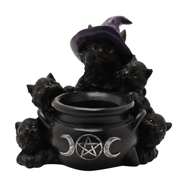 Black resin tealight candle holder shaped as five amber-eyed cats around a cauldron with a triple moon and pentagram emblem, one cat wearing a purple witch's hat, on a plain white background.