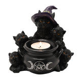 Black resin tealight candle holder shaped as a cauldron with silver pentagram and moon emblem, surrounded by five black cats, one wearing a purple witch's hat, on a white background.