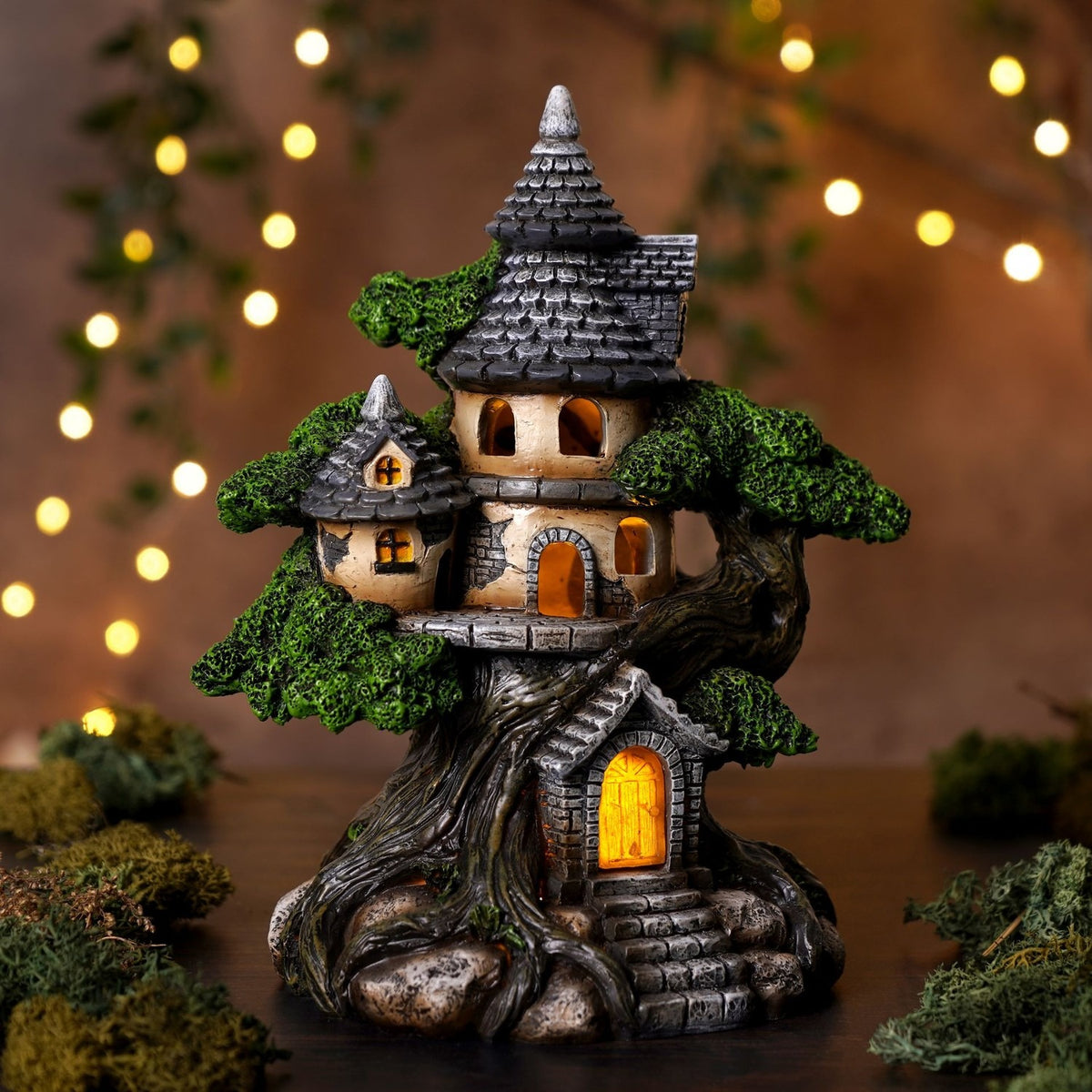 LED Treehouse Resin Light-Up Decoration 19.8cm in grey and green, showing a turreted cottage built into a gnarled tree with stone doorway, steps, and illuminated windows.