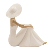 Floor seated lady resin figurine in cream, wide-brimmed hat and textured gown, natural-finish arms and face, one knee drawn up, shown against a plain white background.