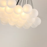 Niori Orb 37 Light Cluster Chandelier in black, with frosted glass globes suspended on fine chains from a matt black rod, glowing warm white.