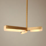 Elvaris LED Radial Alabaster Chandelier in brushed brass, three angular arms with alabaster diffusers glowing warm white, suspended from a slim rod against a plain light background.