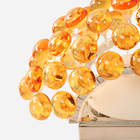 Close-up of the Briller LED Small Wall Light in gold, showcasing its decorative lamp design with circular amber-colored glass panels in a dome shape over a metal frame, offering a warm glow similar to an LED wall light.