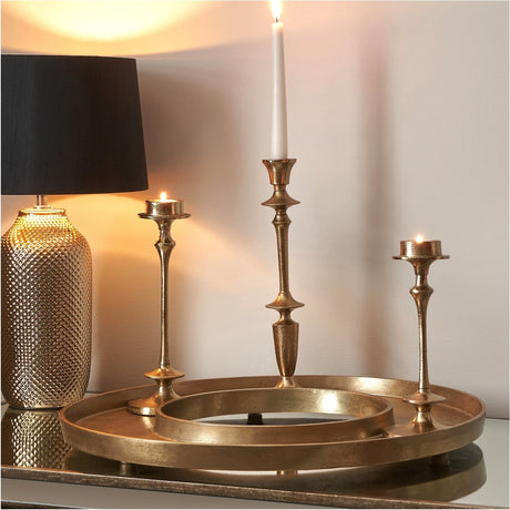 Antique gold aluminium ring display platter, 54 x 54cm, styled on a sideboard with matching candlesticks, tealights, and a textured gold table lamp.