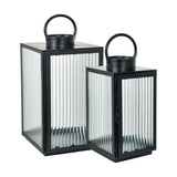 Set of 2 black iron lanterns with ribbed glass panels and curved carry handles, in two heights, on a plain white background.