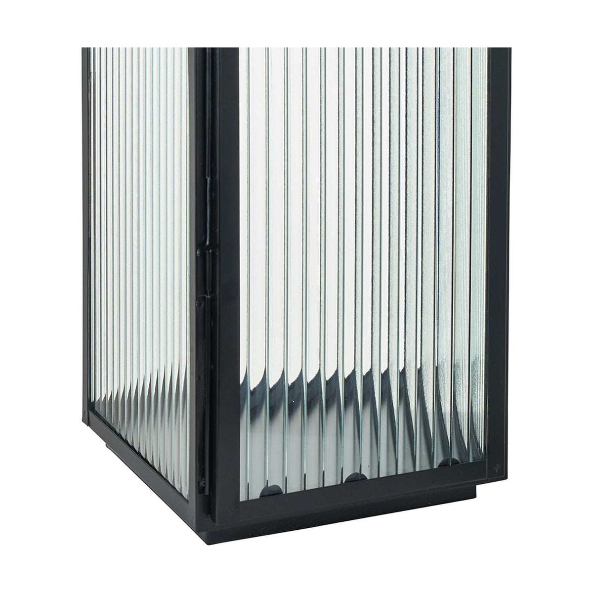 Close-up of a black iron candle lantern with vertical ribbed glass panels and a black base, shown against a plain white background.