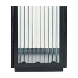 Black iron candle lantern with vertical ribbed glass panels and hinged door detail, shown close-up against a plain white background.