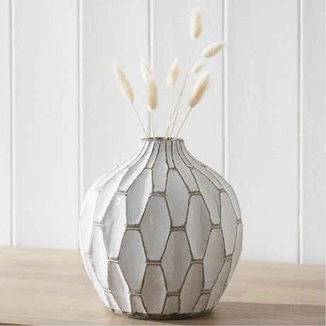 Gaudi White Stoneware Geometric Design Vase, 20cm, rounded ceramic form with honeycomb pattern, holding dried bunny tail grasses on a wooden surface against a white panelled wall.