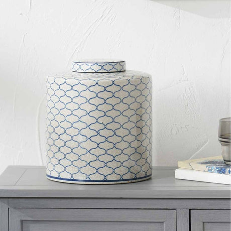 Demetri Grey & Blue Ceramic Lidded Ginger Jar, 24cm, with a quatrefoil pattern, shown on a grey sideboard beside books and a glass in a living room setting.