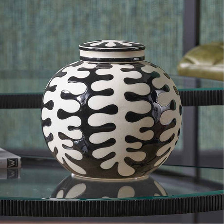 Elkorn Black & White Ceramic Coral Design Lidded Ginger Jar, 20cm, round body with wavy coral pattern and matching lid, shown on a glass table in a living room setting.