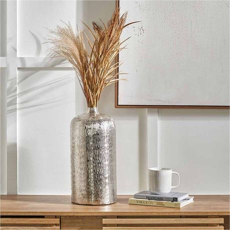 Silver Aluminium Hammered Vase, 38cm, cylindrical with textured finish, holding dried pampas grass on a wooden sideboard beside books and a mug.